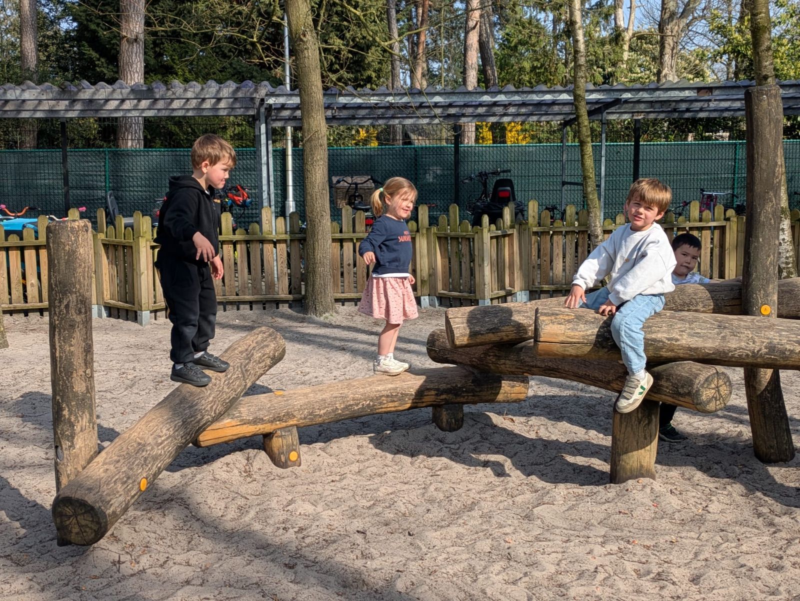 Kleuters spelen op de houten speeltuigen